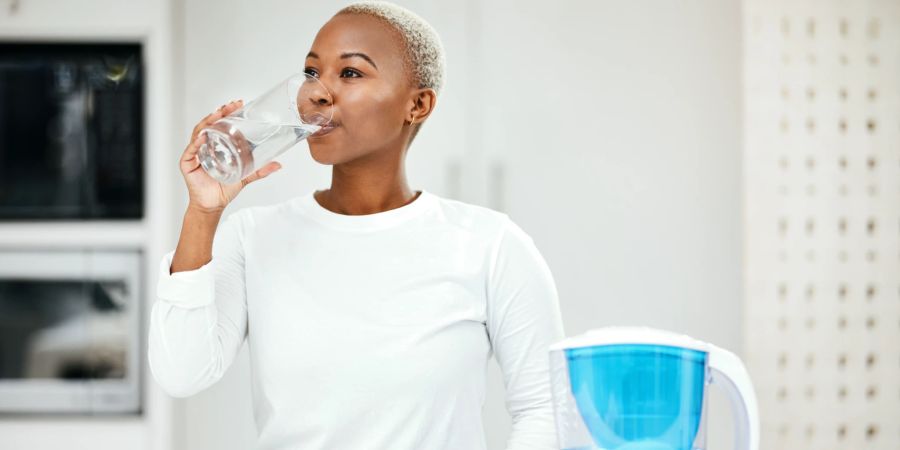 Frau trinkt klares Wasser.