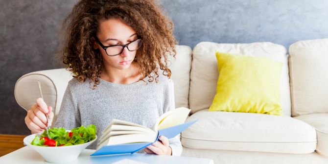 Teenager-Mädchen mit Buch, Salat