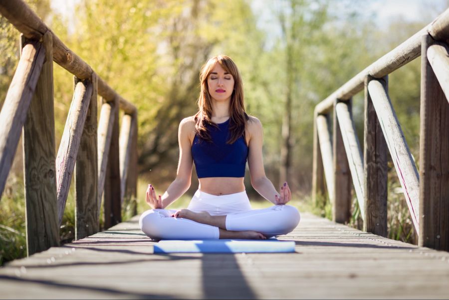 Frau macht Yoga draussen.