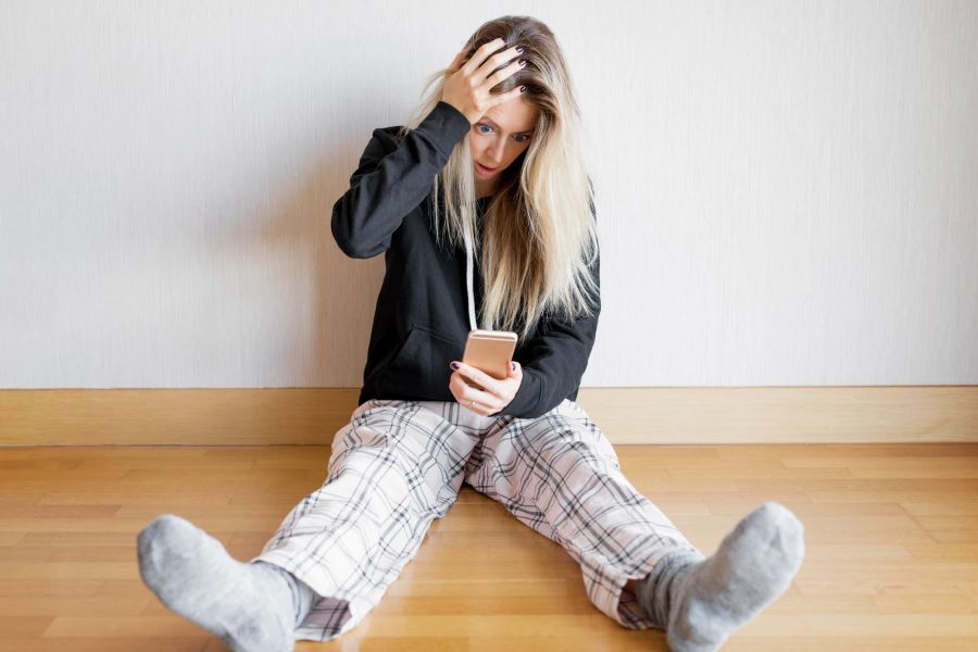 Frau erschocken mit Smartphone