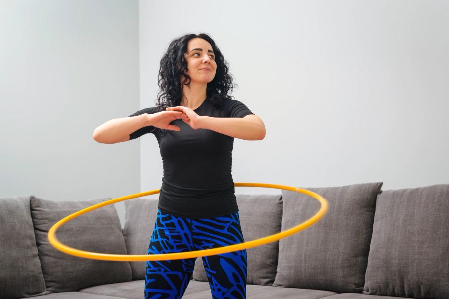 Frau macht zu Hause Hula-Hoop.