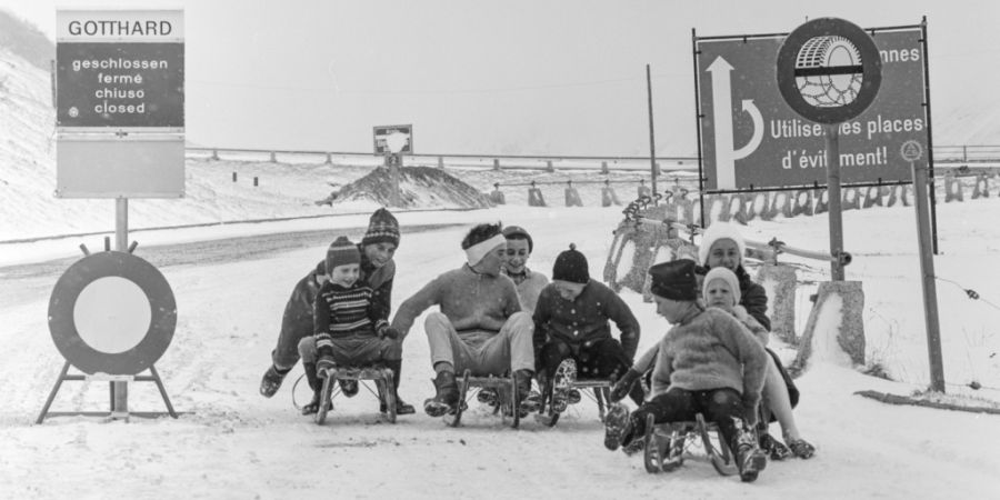 Kinder beim Schlitteln auf der gesperrten Gotthardstrasse bei Hospental im Kanton Uri, aufgenommen im Januar 1962. (Archivbild)