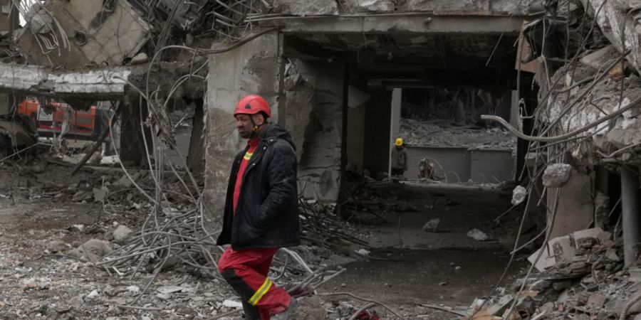 Einsatzkräfte durchsuchen die Trümmer eines Wohnhauses in Teheran. Foto: Vahid Salemi/AP/dpa