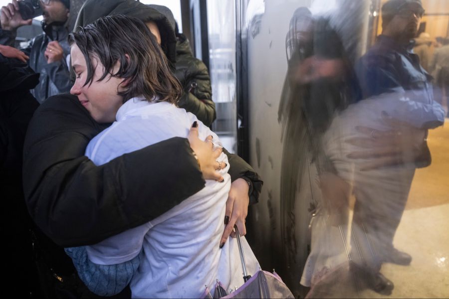 Angehörige der Opfer des tödlichen Brandes in der Bar "Le Constellation" in Crans-Montana umarmen sich vor der Anhörung der Barbesitzer Jacques und Jessica Moretti.