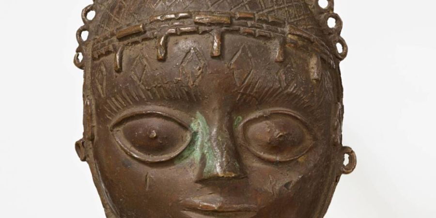 Die Anhängermaske Uhunmwu-Ẹkuẹ wurde Ende des 19. Jahrhunderts im damaligen Königreich Benin (heute Nigeria) geplündert und kam später ins Museum Rietberg in Zürich. Die Anhän...
