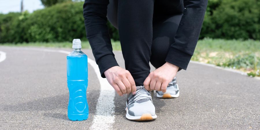 Sporter mit Laufschuhen, Energydrink