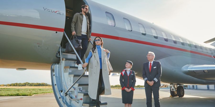 Elegante Reisende steigen aus Privathet von VistaJet aus.