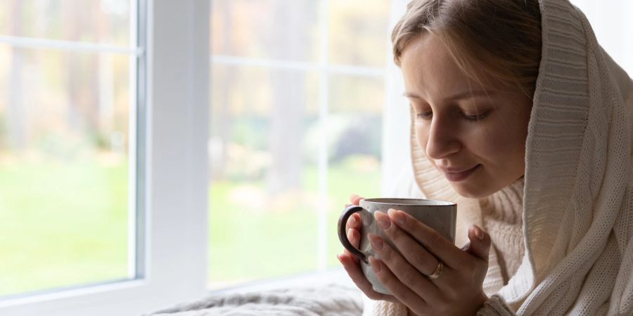 Frau mit Tee auf dem Sofa