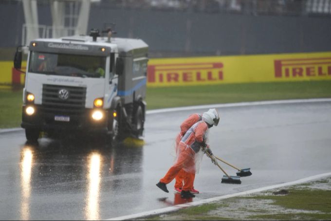Die Streckenposten säubern bei der Formel 1 die Strecke von Wasser, nachdem Regen den Beginn des Qualifikationsrennens verzögert hat. Formel 1