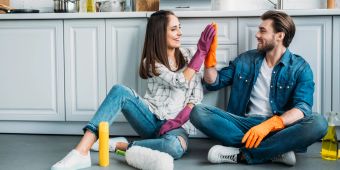 Junges Paar sitzt auf dem Boden nach dem Putzen der Küche