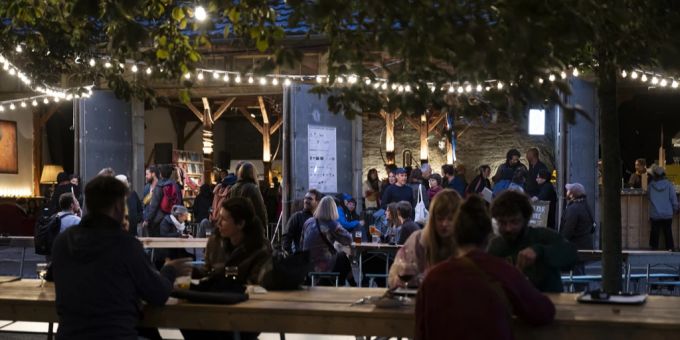 Menschen dinieren bei dem Belluard-Bollwerk-Festival in einem Restaurant. Belluard-Bollwerk-Festival