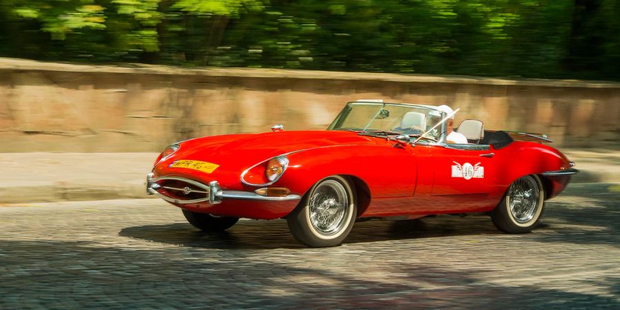 Roter Jaguar E-Type Cabrio auf der Strasse im Sonnenschein.