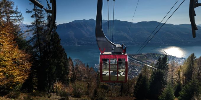 Die Luftseilbahn Cardada verfügt über eine der modernsten Digitaltechniksysteme der Schweiz, die eine sichere Fahrt ermöglichen – egal ob bei Wind, Regen oder Schnee. Cardada Fahrbahn Ausblick Gondel Tal mit See und Stadtkulisse