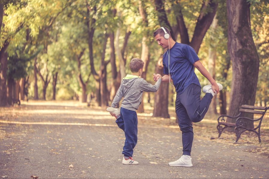 Kleiner Junge und sein Vater beim gemeinsamen Sport im Freien