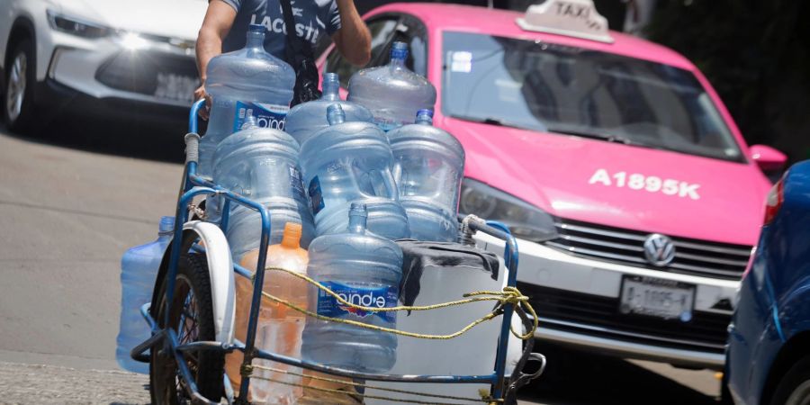 Ein Mann geht mit leeren Wasserkanistern durch eine Strasse in Mexiko-Stadt. In 27 der 32 Bundesstaaten in Mexiko liegen die Temperaturen bei mehr als 40 Grad.