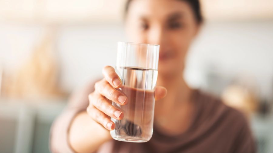 Nahaufnahme Wasserglas, das von einer Person gehalten wird