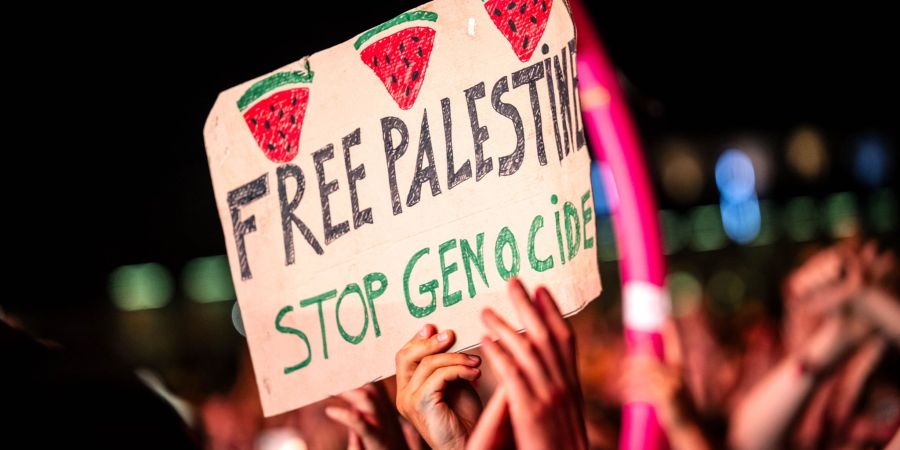 «Free Palestine - Stop Genocide» steht auf einem Plakat bei dem Auftritt vom US-Rapper Macklemore. Es war eine von wenigen politischen Botschaften im Publikum.