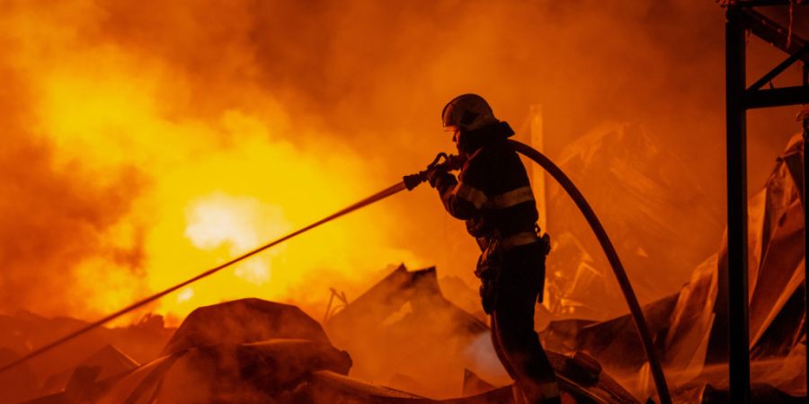 dpatopbilder - Feuerwehrleute löschten einen Brand, nachdem russische Raketen ein Lagerhaus getroffen hatten. Foto: Dan Bashakov/AP/dpa