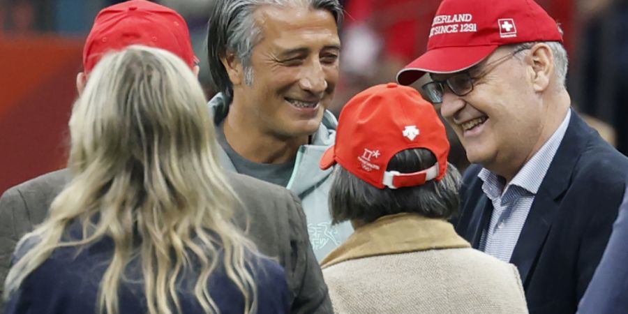 Der Schweizer Fussball-Nationaltrainer Murat Yakin schmunzelt vor dem Sechzehntelfinanspiel gegen Algerien - vielleicht wegen der Mütze von Bundespräsident Guy Parmelin neben ihm.