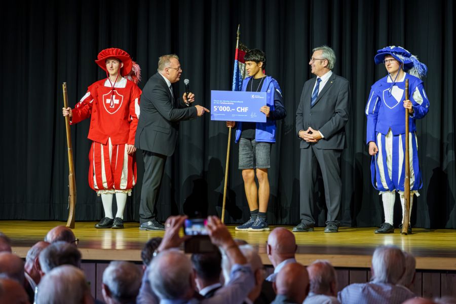 Mark Roth (links) übergibt dem Schützenkönig Julian Zehnder (Mitte) den traditionellen Check über 5000 Franken von der Zürcher Kantonalbank.
