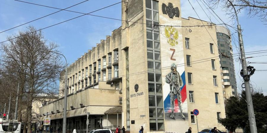 ARCHIV - An der Fassade der Hauptpost im Zentrum der Hauptstadt der Schwarzmeer-Halbinsel Krim erinnert ein großes Wandbild an die «militärische Spezialoperation», wie Russland sein...