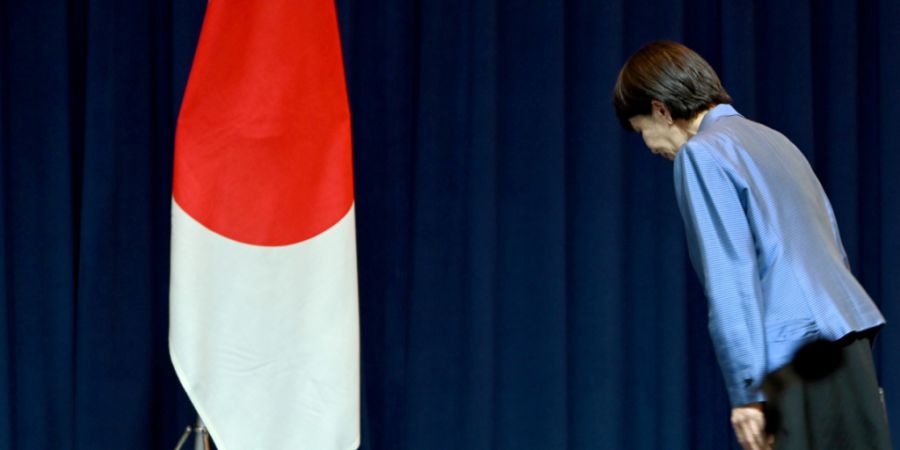 ARCHIV - Sanae Takaichi, Ministerpräsidentin Japans, verneigt sich auf einer Pressekonferenz vor der japanischen Flagge. Foto: Johannes Neudecker/dpa
