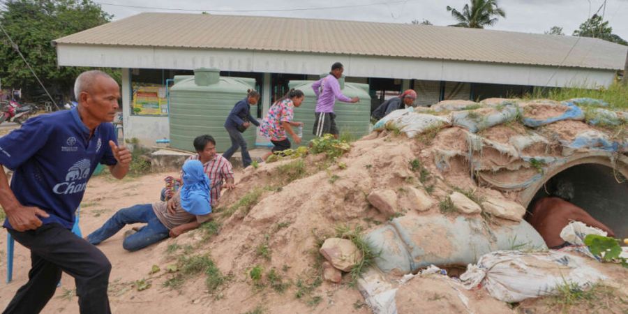 dpatopbilder - Freiwillige der Dorfsicherheit und Anwohner rennen in einen Schutzraum, als Explosionen in der thailändischen Provinz Buriram nach dem erneuten Grenzkonflikt zwischen Th...