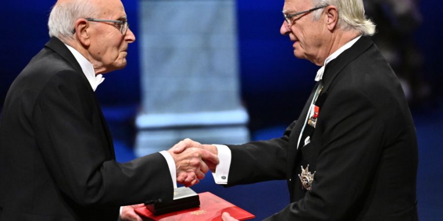 Chemie-Nobelpreisträger Richard Robson (l) erhält seinen Preis von König Carl Gustaf bei der Nobelpreisverleihung in Stockholm. Foto: Anders Wiklund/TT News Agency/AP/dpa