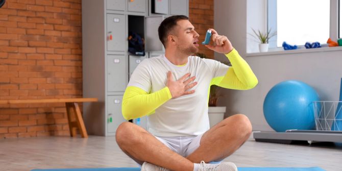 Asthmatiker im Sportraum mit Asthmaspray