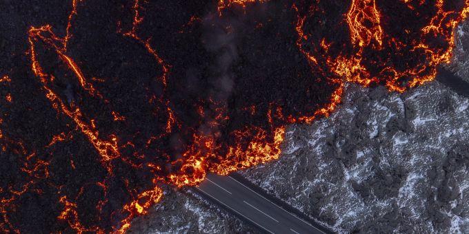 Geschmolzene Lava fliesst auf der Strasse zur Blauen Lagune, Grindavik, nach einem Vulkanausbruch, der am Vortag begann, auf der Halbinsel Reykjanes in Island, 21. November 2024. Island Lava