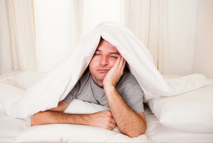 In der ersten Nacht im Hotel schlecht geschlafen? Möglicherweise verbirgt sich dahinter der «First Night Effect». Müder Mann im Bett