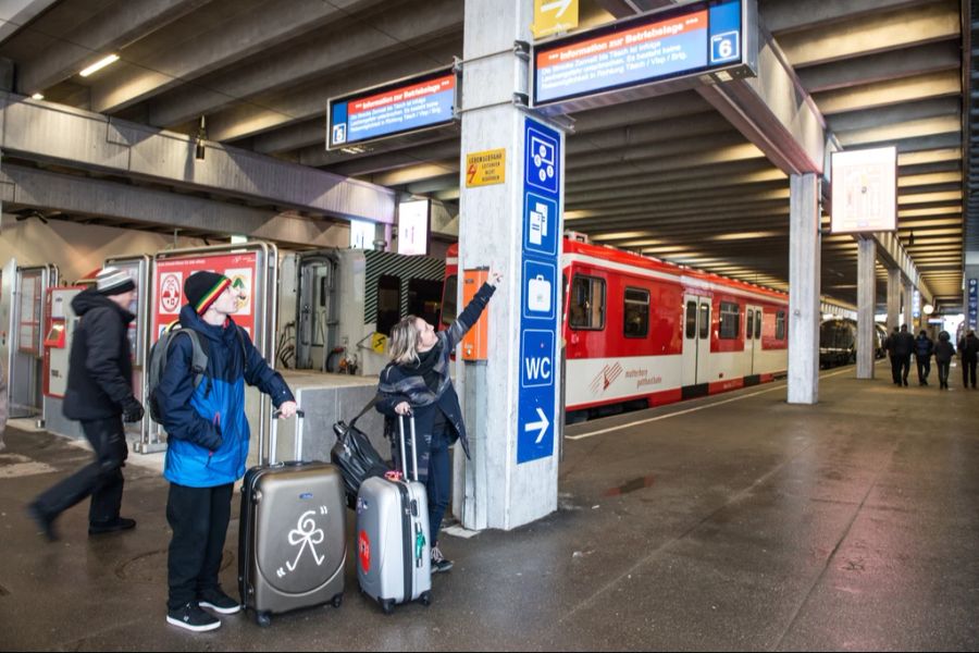 Am Bahnhof in Zermatt zieht sie ihre Skischuhe aus.