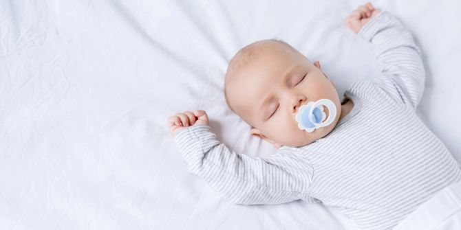 baby schläft mit armen über dem kopf