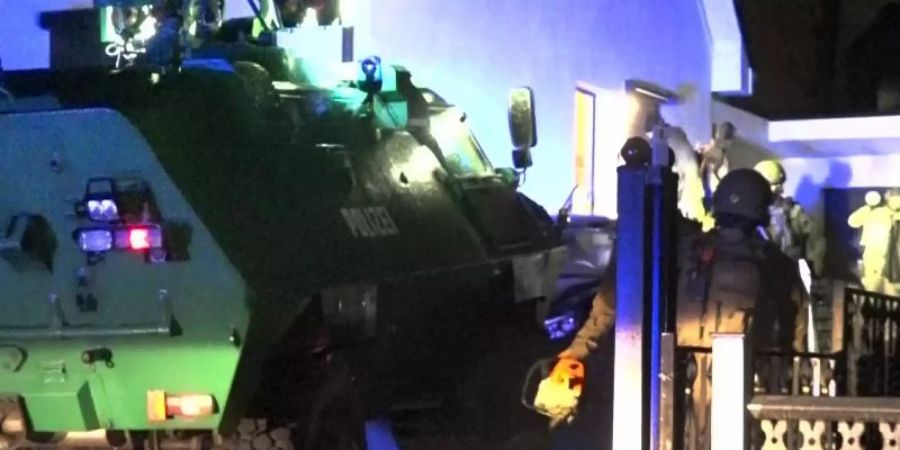 Ein gepanzertes Polizeifahrzeug steht in der Einfahrt zu einem Haus in Dortmund. Foto: Kai Uwe Hagemann/dpa
