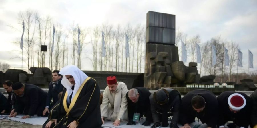 Muslime beten vor dem Denkmal in Auschwitz-Birkenau