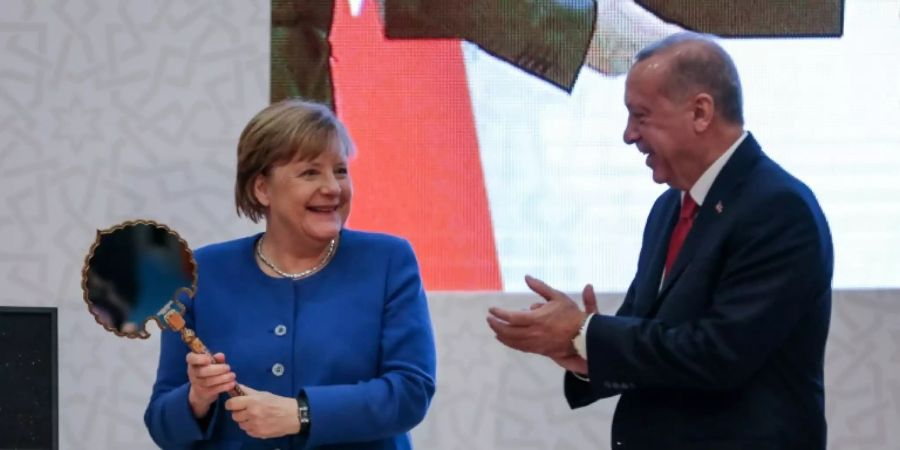 Merkel freut sich über einen Spiegel als Gastgeschenk