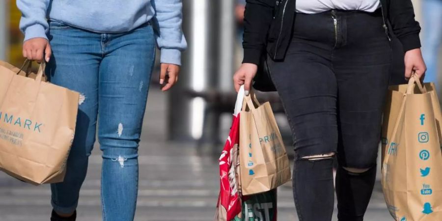 Zwei Frauen mit Einkaufstaschen der Modekette Primark flanieren in Dresden. Foto: Monika Skolimowska/dpa-Zentralbild/dpa