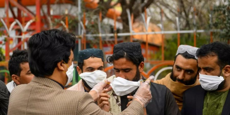 Freiwillige verteilen in Herat Atemschutzmasken