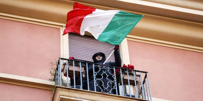 Ein Junge mit einer italienischen Flagge steht auf einem Balkon während eines Flashmobs, der in ganz Italien läuft, um Menschen zusammenzubringen und zu versuchen, den Corona-Notstand in Italien zu bewältigen, Coronavirus in Italien