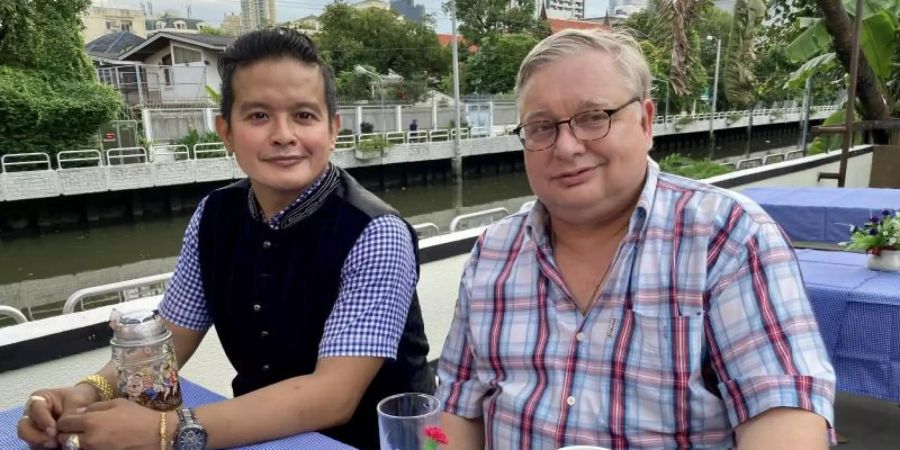 Kevyn Michel (l.), Besitzer des Traditionslokals «Bei Otto», und der deutsche Auswanderer Hermann Quint auf der Aussenterrasse der neuen Wirtschaft direkt am Kanal. Foto: Carola Frentzen/dpa