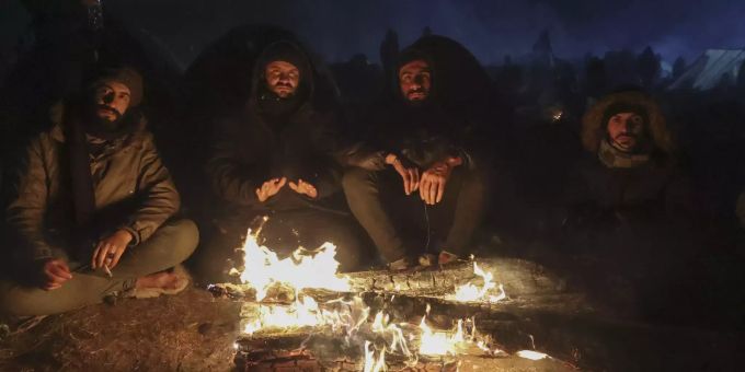 Migranten wärmen sich an einem Feuer, während sie sich am Kontrollpunkt "Kuznitsa" an der weißrussisch-polnischen Grenze in der Nähe von Grodno (Weißrussland) versammeln, Mittwoch, 17. November 2021. Migration Belarus Poland
