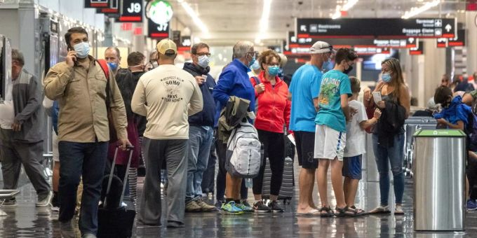 Passagiere stehen in einer Schlange am Flughafen Miami. corona