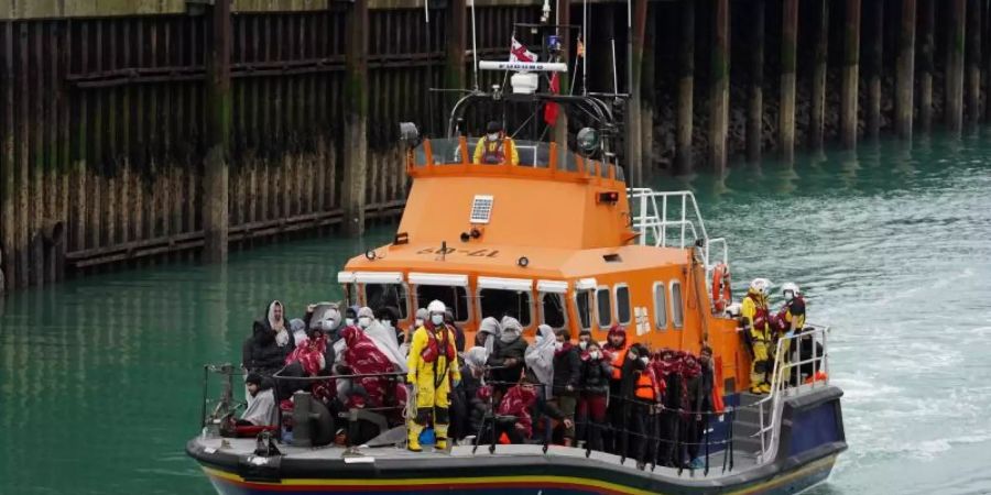 Eine Gruppe von Menschen, bei denen es sich vermutlich um Migranten handelt, wird an Bord des Dover-Rettungsboots an Land gebracht. Foto: Gareth Fuller/PA Wire/dpa