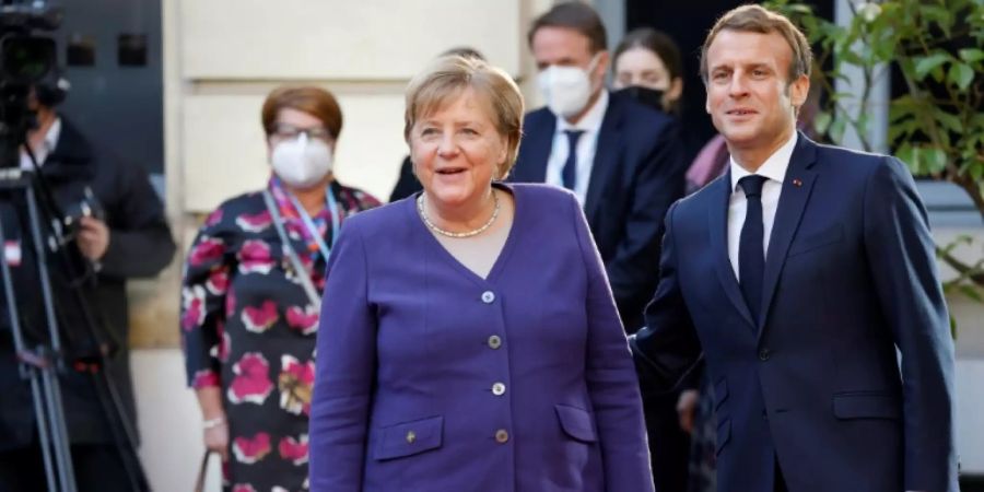 Merkel im blauen Blazer mit Frankreichs Präsident Macron