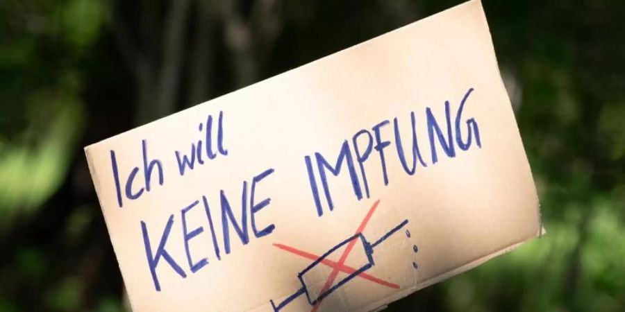 Ein Schild mit der Aufschrift «Ich will keine Impfung» am Rande einer Kundgebung in Dresden. Foto: Sebastian Kahnert/dpa