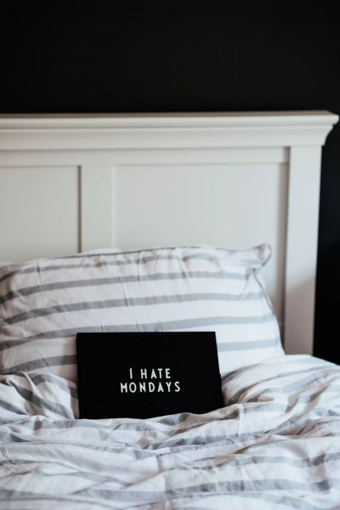 Arbeitszeiten an den Biorhythmus anpassen? Auch das kann helfen, Montags leichter aus dem Bett zu kommen. Schild auf Bett "I hate Mondays".