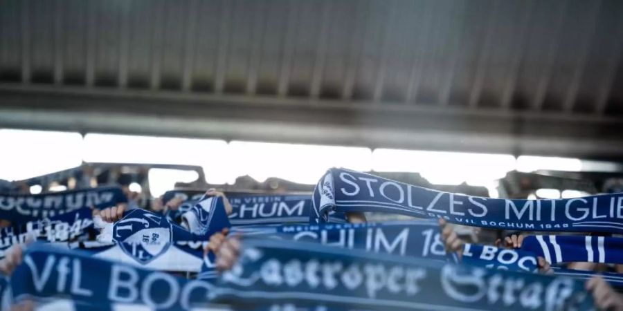 13.799 Zuschauer sind im Vonovia Ruhrstadion für das Spiel von Borussia Dortmund in Bochum zugelassen; VfL-Fans halten Schals hoch. Foto: Fabian Strauch/dpa