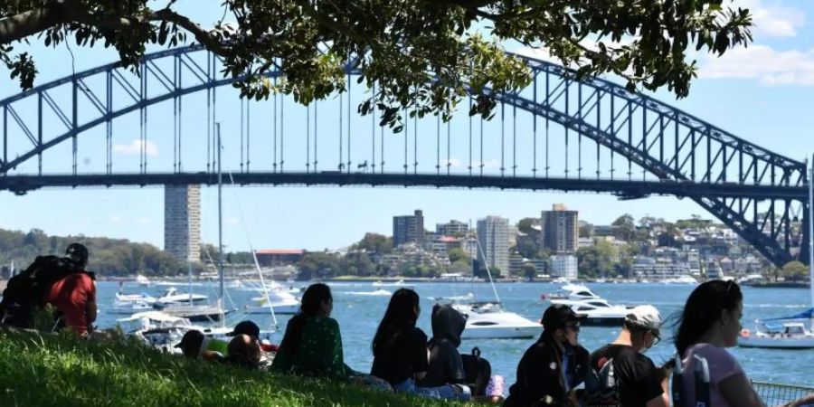 Vor den Silvesterfeierlichkeiten in Sydney versammelt sich eine kleine Menschenmenge an einem Aussichtspunkt mit Blick auf die Harbour Bridge. Foto: Dean Lewins/AAP/dpa