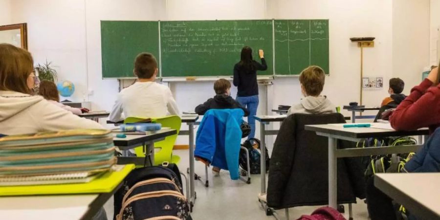 Schülerinnen und Schüler einer fünften Klasse sitzen während dem Unterricht in ihrem Klassenzimmer. Foto: Philipp von Ditfurth/dpa