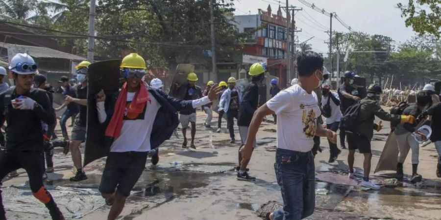 Anti-Putsch-Demonstranten ziehen sich von den behelfsmässigen Barrikaden zurück, nachdem Bereitschaftspolizisten Schallbomben und Gummigeschosse abgefeuert hatten. Foto: Uncredited/AP/dpa